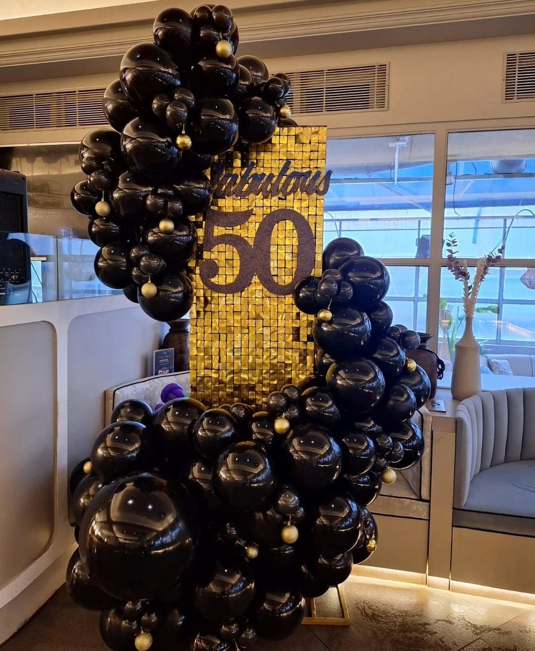 Festival and party balloon decoration in black and gold with shimmer wall
